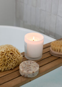 spa board on tub with candle and bath sponges